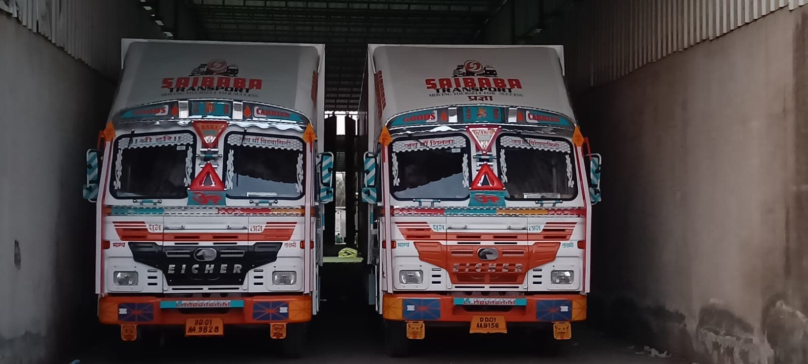 Two Saibaba Transport trucks parked at the warehouse